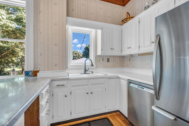 408 E Wabash Ave, Crawfordsville, IN 47933 - kitchen featuring stainless steel appliances, wallpapered walls, white cabinets, and light wood-style floors
