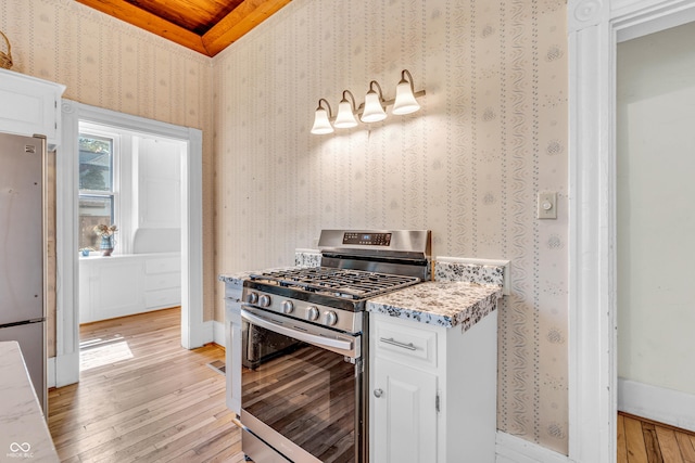408 E Wabash Ave, Crawfordsville, IN 47933 - kitchen with appliances with stainless steel finishes, light wood-style floors, white cabinetry, and wallpapered walls