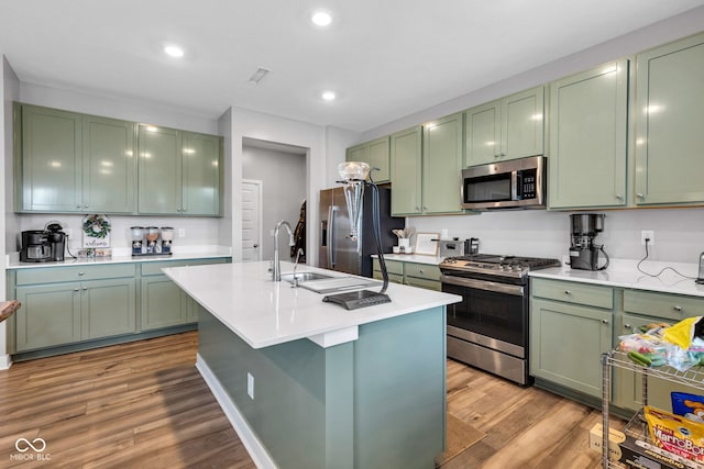 11480 Plough St, Noblesville, IN 46060 - kitchen with green cabinetry, appliances with stainless steel finishes, wood finished floors, light countertops, and recessed lighting