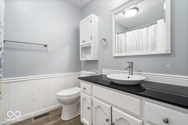 3628 Paddington Cir, Indianapolis, IN 46268 - full bath featuring wood finished floors, vanity, wainscoting, and a textured ceiling