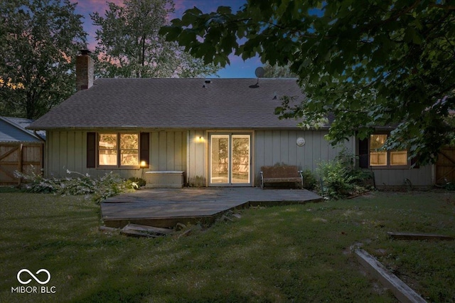 3628 Paddington Cir, Indianapolis, IN 46268 - back of property at dusk with a chimney, a wooden deck, board and batten siding, and a shingled roof