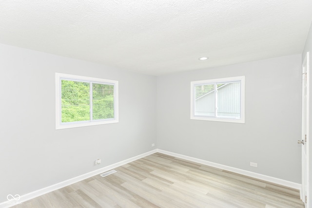 2521 Winfield Ave, Indianapolis, IN 46222 - empty room featuring light wood finished floors, healthy amount of natural light, recessed lighting, and a textured ceiling