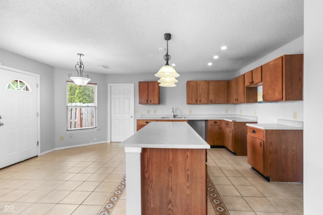 12443 Rose Haven Dr, Indianapolis, IN 46235 - kitchen featuring a textured ceiling, brown cabinetry, light tile patterned floors, a center island, and pendant lighting
