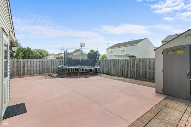 12443 Rose Haven Dr, Indianapolis, IN 46235 - fenced backyard featuring a patio area, a trampoline, a storage unit, and a residential view