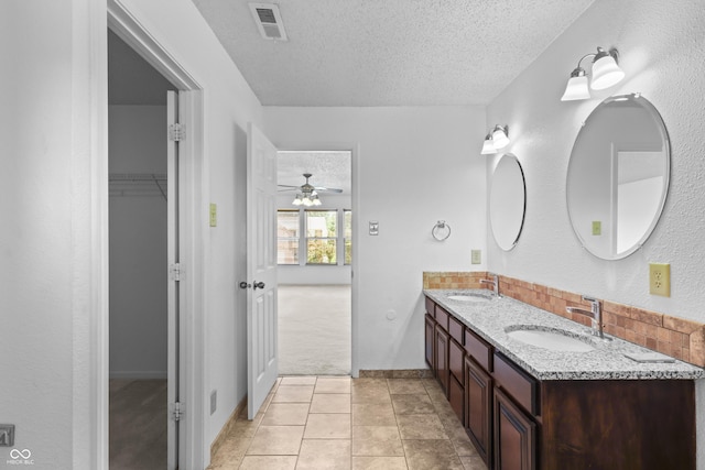 12443 Rose Haven Dr, Indianapolis, IN 46235 - full bathroom with a textured ceiling, double vanity, a ceiling fan, decorative backsplash, and a spacious closet