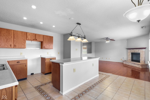 12443 Rose Haven Dr, Indianapolis, IN 46235 - kitchen with light tile patterned floors, a center island, brown cabinets, ceiling fan, and recessed lighting