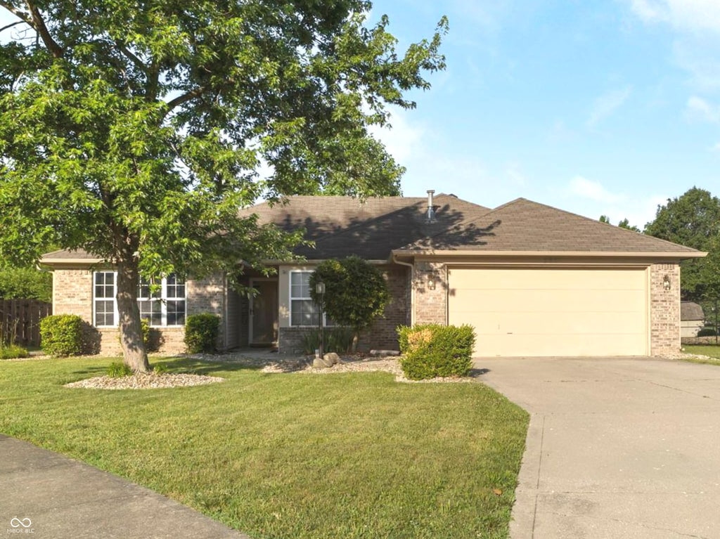 282 N Greenbriar Dr, Greenwood, IN 46142 - single story home featuring brick siding, an attached garage, driveway, a front lawn, and roof with shingles