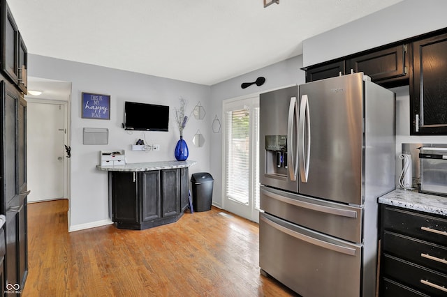 826 Royal Saint George Dr, Greenwood, IN 46143 - kitchen featuring stainless steel refrigerator with ice dispenser, light wood-style flooring, light stone counters, and dark cabinetry