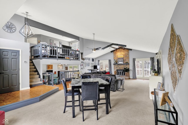 826 Royal Saint George Dr, Greenwood, IN 46143 - dining area featuring high vaulted ceiling, ceiling fan, light carpet, a fireplace, and stairs