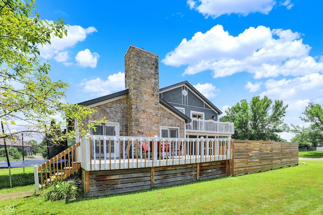 826 Royal Saint George Dr, Greenwood, IN 46143 - rear view of house with a wooden deck, a trampoline, a chimney, stone siding, and stairway