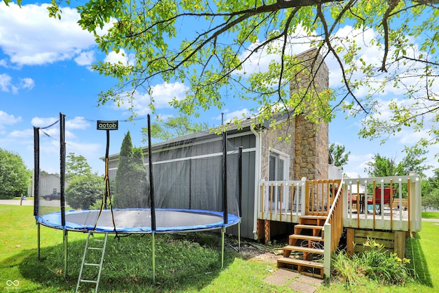 826 Royal Saint George Dr, Greenwood, IN 46143 - rear view of house featuring a trampoline, a deck, a yard, and a chimney