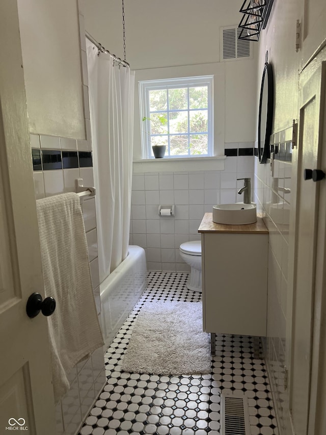 2131 Union St, Lafayette, IN 47904 - full bathroom featuring tile walls, tile patterned flooring, vanity, shower / bath combo with shower curtain, and a wainscoted wall