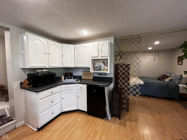 2131 Union St, Lafayette, IN 47904 - kitchen with black appliances, light wood finished floors, dark countertops, white cabinets, and a textured ceiling