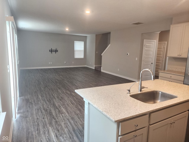 2431 S Carlota Dr, New Palestine, IN 46163 - kitchen featuring dark wood finished floors, light stone countertops, a center island with sink, recessed lighting, and open floor plan