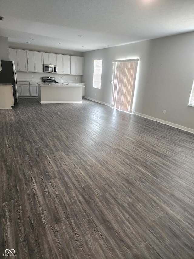 2431 S Carlota Dr, New Palestine, IN 46163 - unfurnished living room featuring a sink and dark wood-style floors