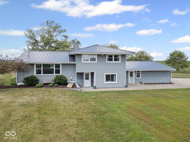 10227 E 500 S, Otterbein, IN 47970 - tri-level home featuring a patio area, a chimney, a front yard, a metal roof, and a standing seam roof
