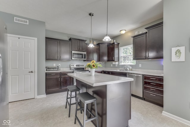 12291 Falling Leaves Trl, Indianapolis, IN 46229 - kitchen featuring stainless steel appliances, a breakfast bar, dark brown cabinets, light countertops, and a center island