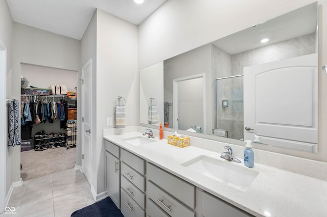 2584 Lanai Ln, Greenwood, IN 46143 - bathroom with double vanity, a shower stall, a spacious closet, and tile patterned floors