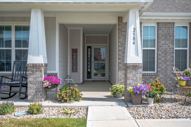 2584 Lanai Ln, Greenwood, IN 46143 - doorway to property with a porch, brick siding, and roof with shingles