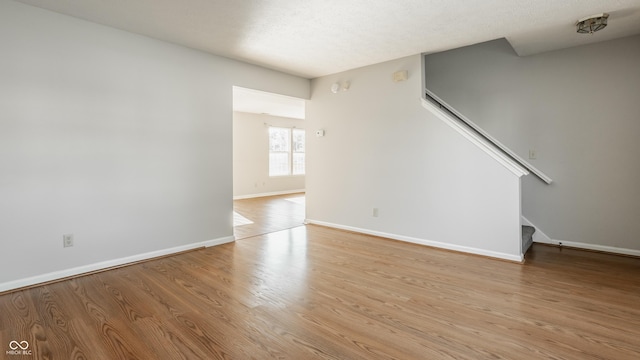 3923 N Bressingham Dr, Indianapolis, IN 46235 - unfurnished living room with stairs and light wood-style floors