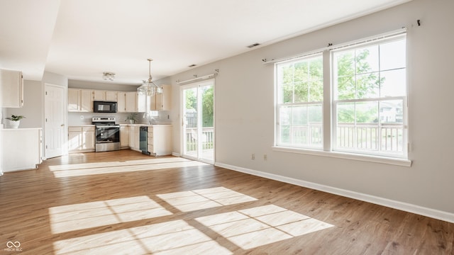 3923 N Bressingham Dr, Indianapolis, IN 46235 - kitchen featuring black appliances, light wood-style flooring, light countertops, and decorative light fixtures