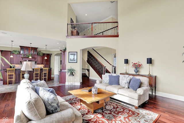 523 S 700 E, Whitestown, IN 46075 - living area featuring arched walkways, dark wood finished floors, stairs, a high ceiling, and crown molding