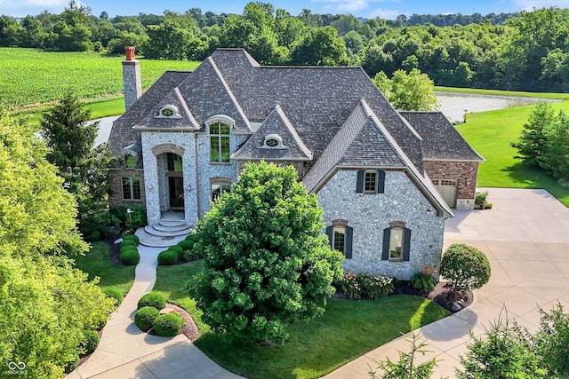 523 S 700 E, Whitestown, IN 46075 - french country style house featuring a chimney, brick siding, driveway, a front yard, and an attached garage