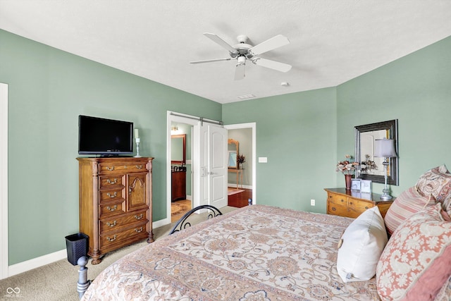 523 S 700 E, Whitestown, IN 46075 - bedroom with light carpet, a barn door, a ceiling fan, and ensuite bath