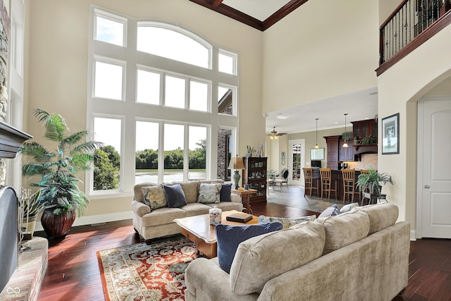523 S 700 E, Whitestown, IN 46075 - living area featuring a towering ceiling, dark wood finished floors, a ceiling fan, ornamental molding, and arched walkways