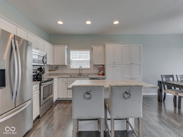 8330 Whitaker Valley Blvd, Indianapolis, IN 46237 - kitchen with stainless steel appliances, white cabinets, dark wood-style flooring, recessed lighting, and a textured ceiling