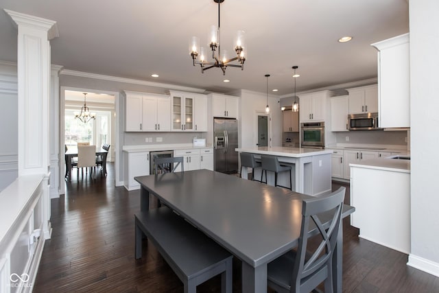 10334 Strongbow Rd, Fishers, IN 46040 - dining room with a chandelier, crown molding, recessed lighting, dark wood finished floors, and ornate columns
