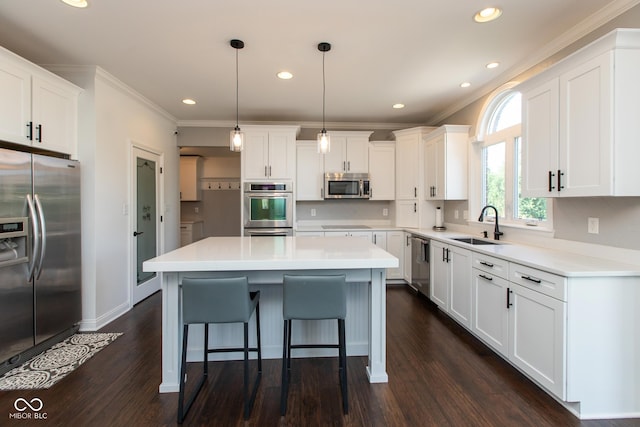 10334 Strongbow Rd, Fishers, IN 46040 - kitchen with stainless steel appliances, crown molding, white cabinetry, a kitchen bar, and dark wood finished floors