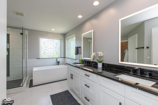 10334 Strongbow Rd, Fishers, IN 46040 - full bathroom with double vanity, a soaking tub, a shower stall, recessed lighting, and tile patterned floors