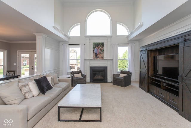 10334 Strongbow Rd, Fishers, IN 46040 - carpeted living area with a glass covered fireplace, a towering ceiling, and crown molding