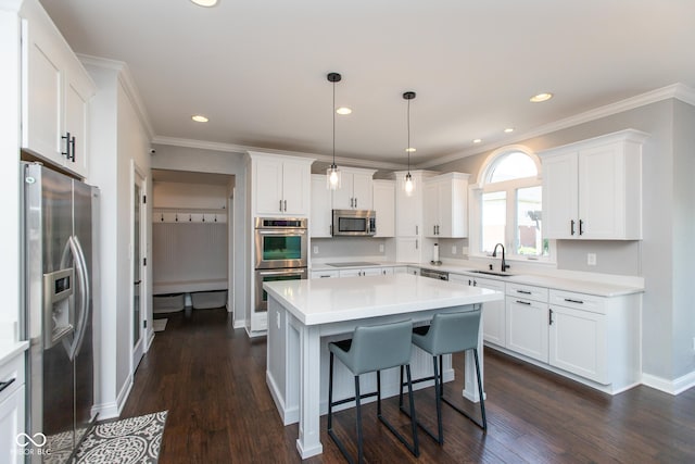 10334 Strongbow Rd, Fishers, IN 46040 - kitchen featuring stainless steel appliances, white cabinetry, light countertops, a kitchen island, and a kitchen bar