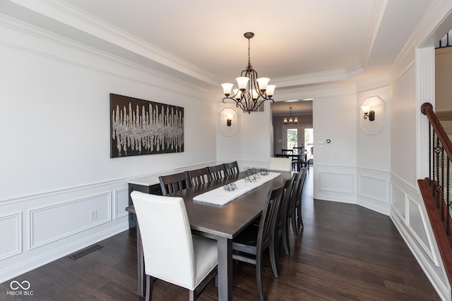 10334 Strongbow Rd, Fishers, IN 46040 - dining room featuring a chandelier, a decorative wall, dark wood finished floors, wainscoting, and ornamental molding