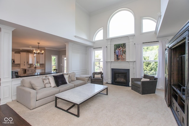 10334 Strongbow Rd, Fishers, IN 46040 - living room with a towering ceiling, a fireplace with flush hearth, a chandelier, and ornamental molding