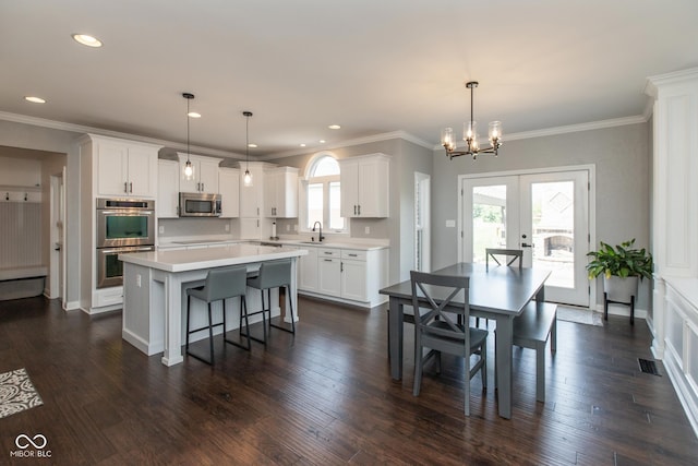 10334 Strongbow Rd, Fishers, IN 46040 - dining area featuring french doors, a chandelier, recessed lighting, dark wood finished floors, and ornamental molding