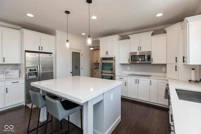 10334 Strongbow Rd, Fishers, IN 46040 - kitchen featuring appliances with stainless steel finishes, a breakfast bar, a kitchen island, white cabinetry, and recessed lighting
