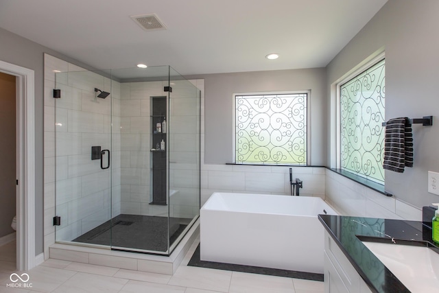 10334 Strongbow Rd, Fishers, IN 46040 - bathroom with a freestanding tub, a shower stall, tile patterned flooring, vanity, and recessed lighting