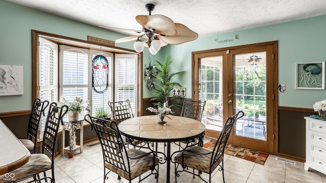5123 Marble Ct, Indianapolis, IN 46237 - dining area featuring french doors, wainscoting, a ceiling fan, light tile patterned floors, and a textured ceiling