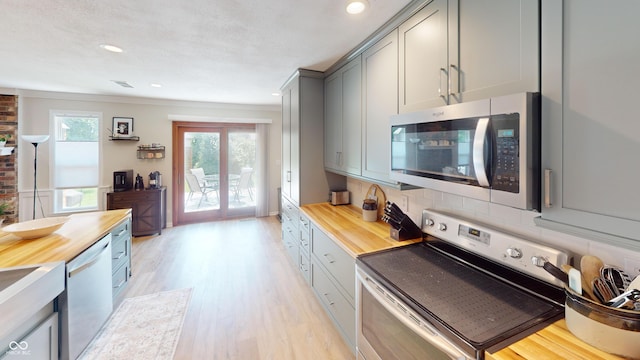 1623 Beech Cir, Plainfield, IN 46168 - kitchen with stainless steel appliances, gray cabinets, butcher block counters, light wood-style floors, and ornamental molding