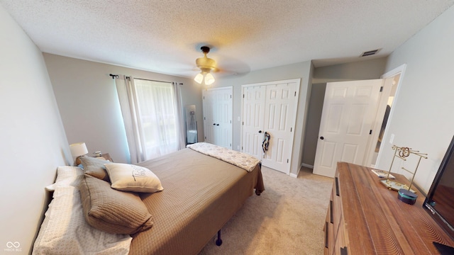 1623 Beech Cir, Plainfield, IN 46168 - bedroom featuring light carpet, ceiling fan, two closets, and a textured ceiling