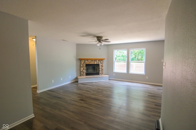 10610 Pavilion Dr, Indianapolis, IN 46259 - unfurnished living room with ceiling fan, dark wood finished floors, a stone fireplace, and a textured wall