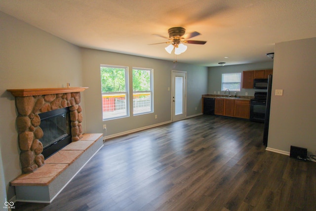 10610 Pavilion Dr, Indianapolis, IN 46259 - unfurnished living room featuring ceiling fan, dark wood-style floors, and a stone fireplace