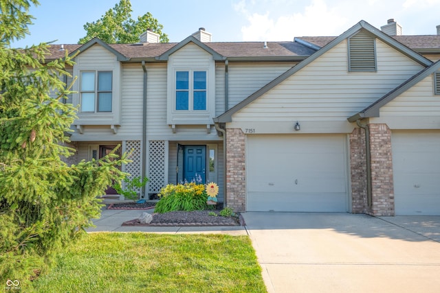 7151 Sea Pine Dr, Indianapolis, IN 46250 - view of front of house with concrete driveway, brick siding, an attached garage, and a chimney
