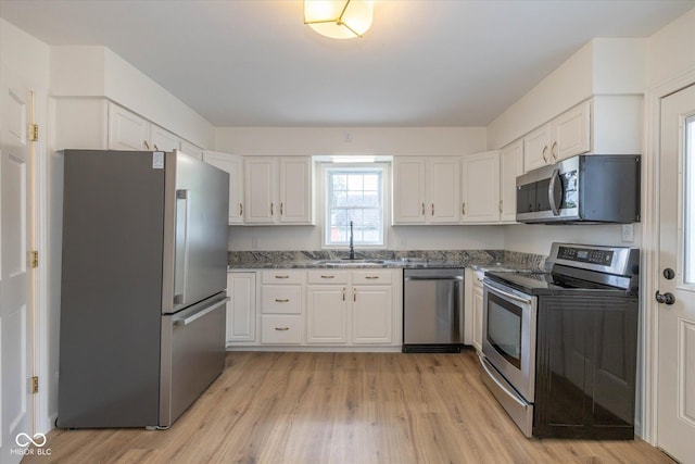 149 E Jackson St, Cicero, IN 46034 - kitchen with appliances with stainless steel finishes, white cabinets, light wood-style floors, and dark stone countertops