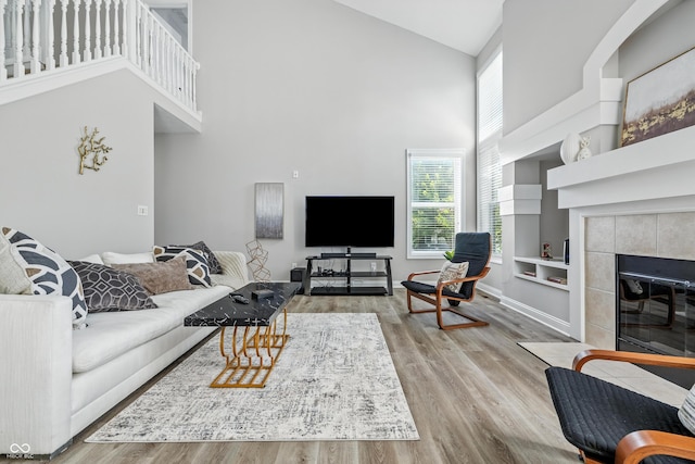 13004 Tuscany Blvd, Carmel, IN 46032 - living room featuring high vaulted ceiling, a fireplace, built in shelves, and wood finished floors
