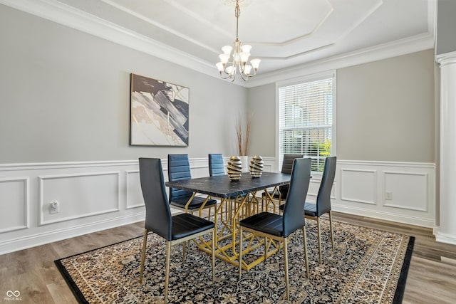 13004 Tuscany Blvd, Carmel, IN 46032 - dining space featuring a chandelier, a raised ceiling, wood finished floors, ornamental molding, and wainscoting