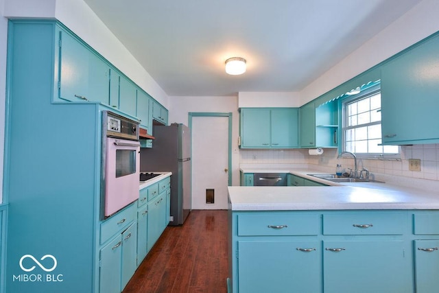7525 Surrey Dr, Indianapolis, IN 46227 - kitchen with appliances with stainless steel finishes, blue cabinetry, tasteful backsplash, and light countertops